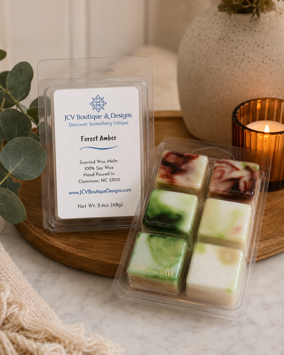 Packaged scented wax melts with a label on a marble surface with a candle and plant in the background.