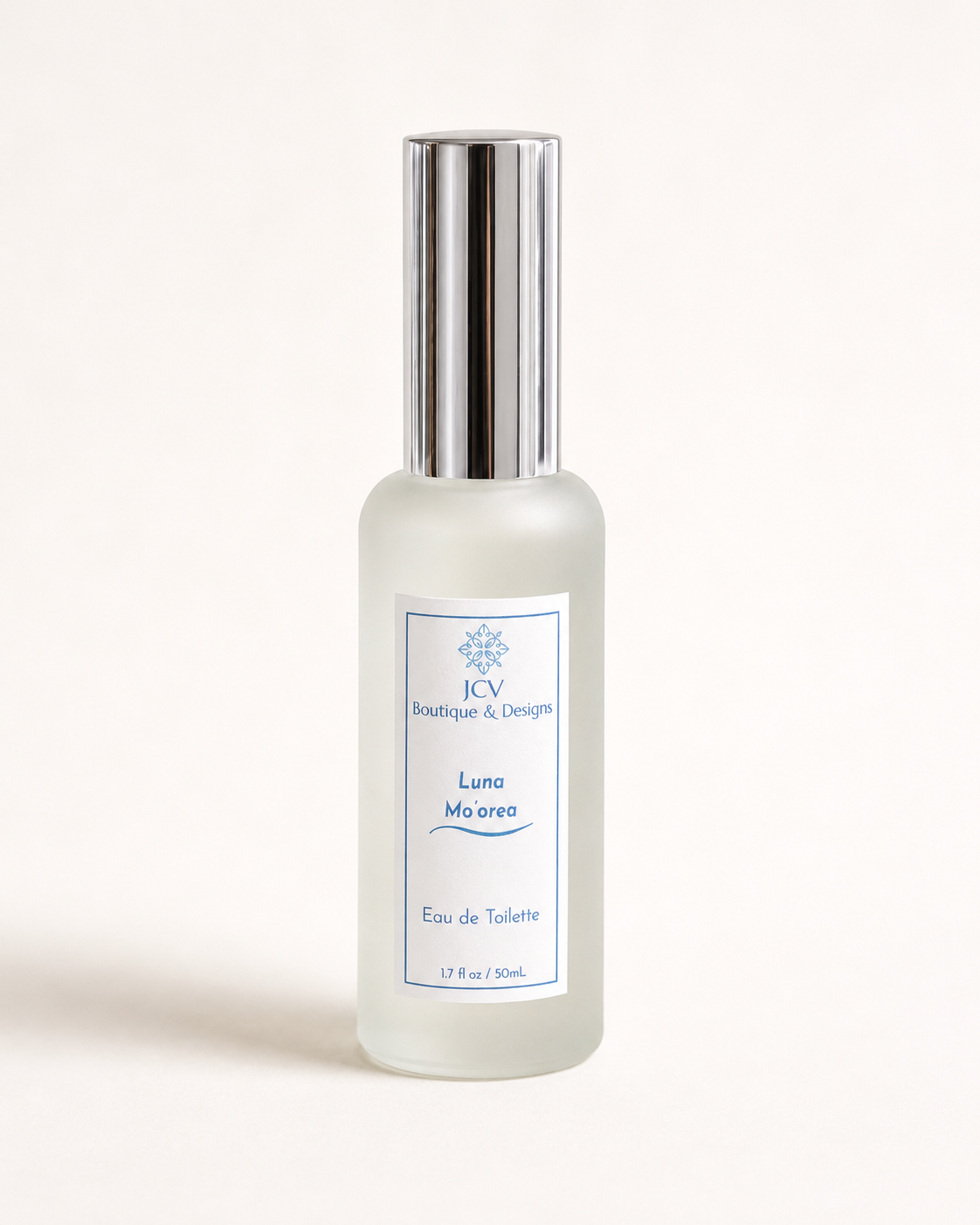 A frosted glass perfume bottle with a reflective silver cap, featuring a white label with blue text that reads 'ICB Boutique & Designs Luna Moeris Eau de Toilette'.